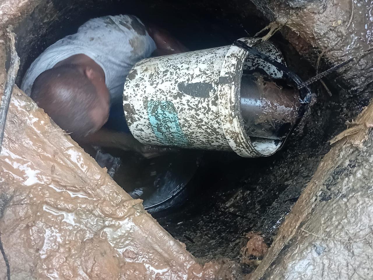 Plumber inspecting a drainage chamber